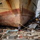 A boy stands in front of a ship and rubble stranded ashore in wake of the tsunami that struck Central Sulawesi.